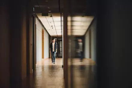 high school student walking down hall alone and worried