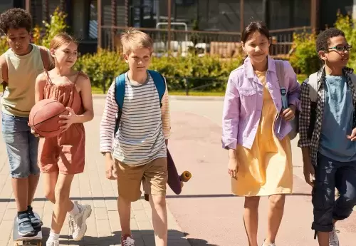youths wearing backpacks walking in a group